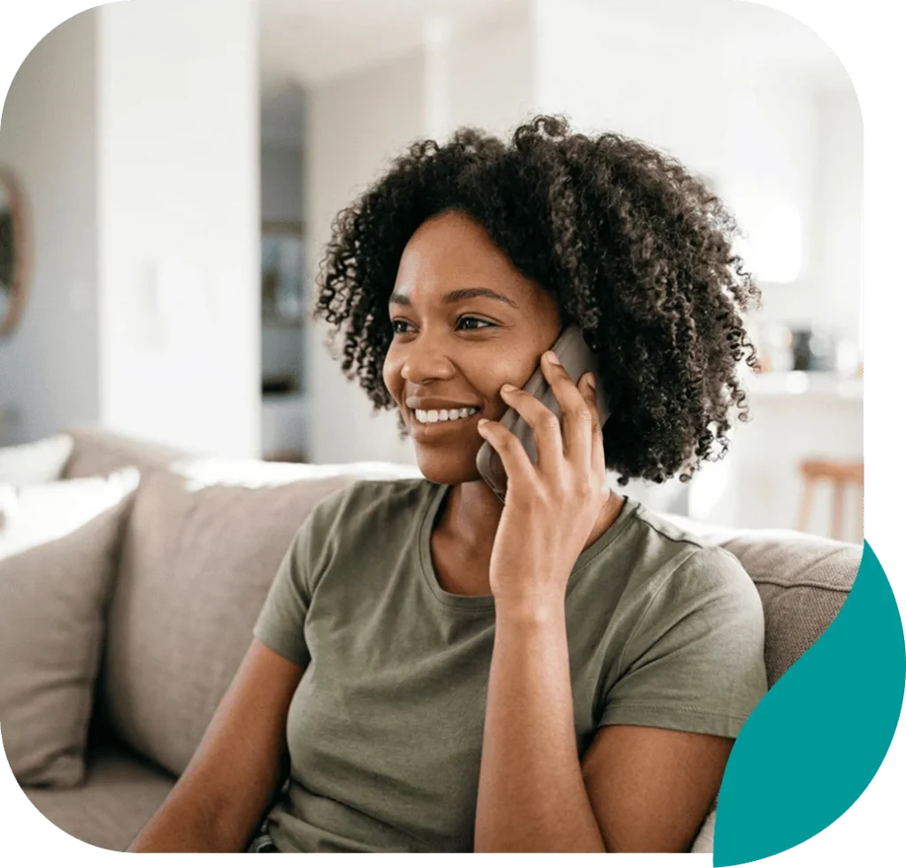 Smiling woman talking on her phone while sitting on a sofa