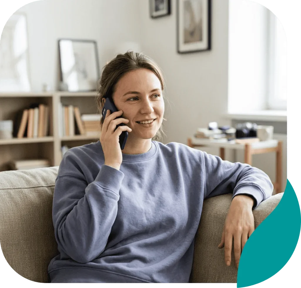 Smiling woman talking on her phone while relaxing on a sofa at home